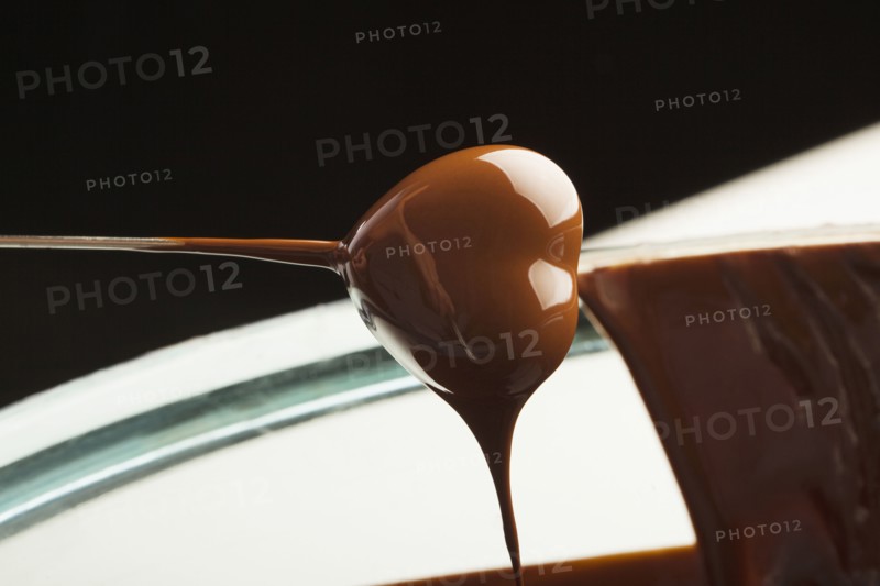 Heart-shaped candy being dipped in chocolate