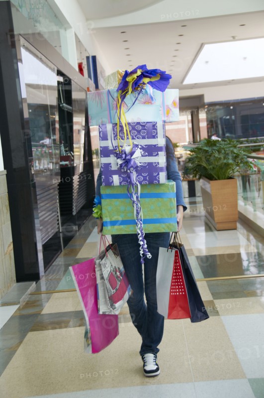 Hispanic teenager carrying gifts in shopping mall