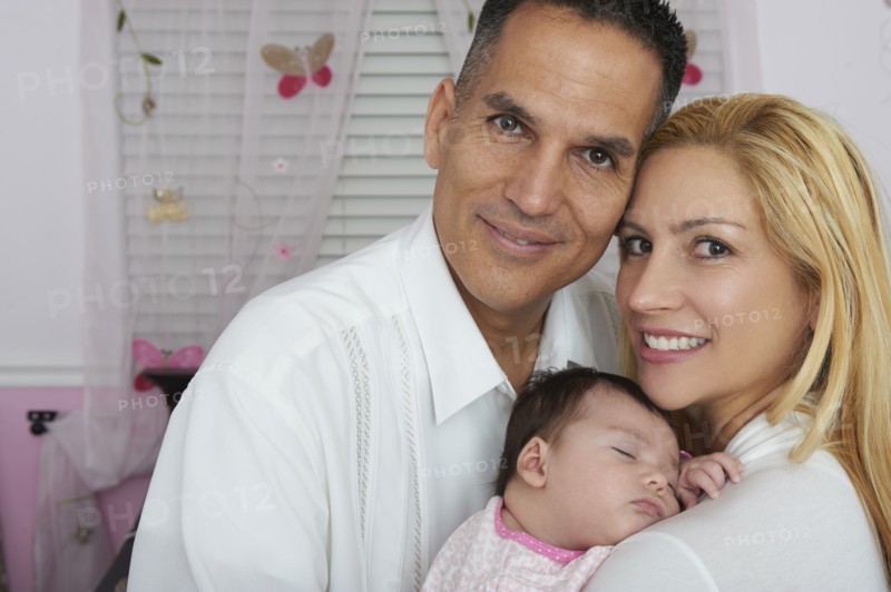 Hispanic parents holding baby daughter
