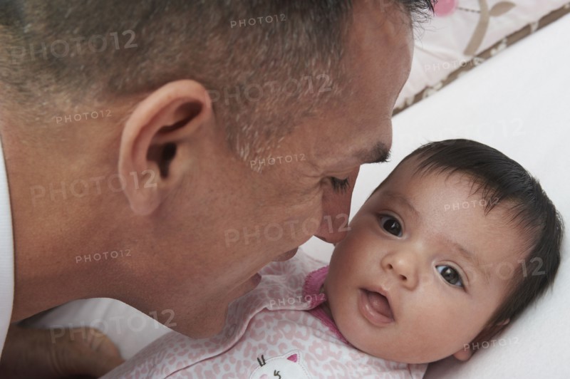Hispanic father bonding with baby daughter