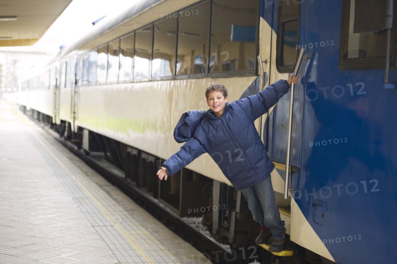 Hispanic boy standing on stairs of train