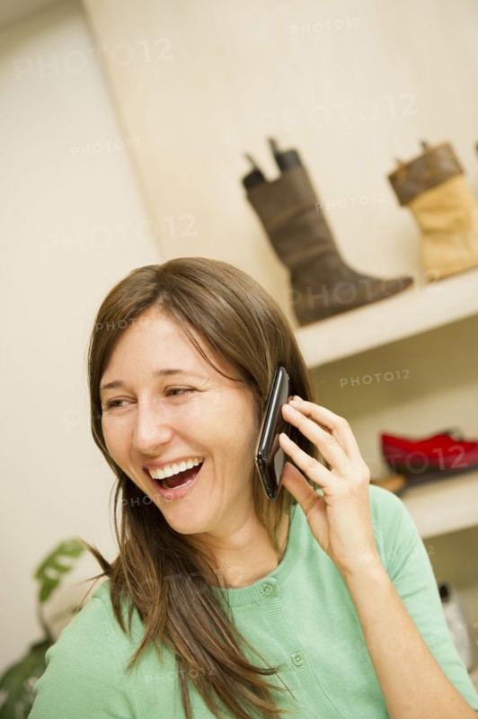 Hispanic woman talking on cell phone in shoe store
