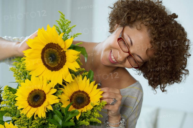 Hispanic woman arranging sunflowers
