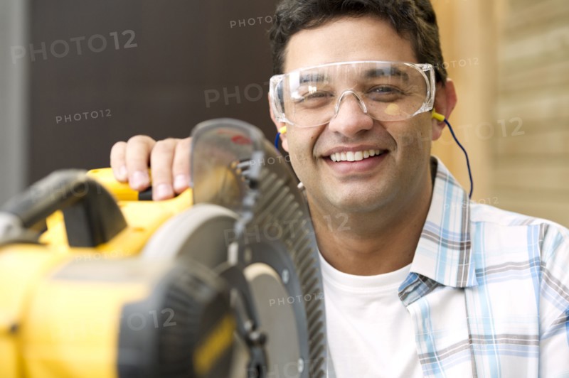 Hispanic carpenter standing with saw