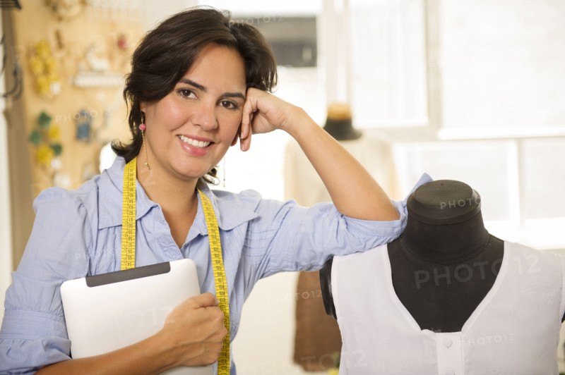 Hispanic dressmaker smiling in studio
