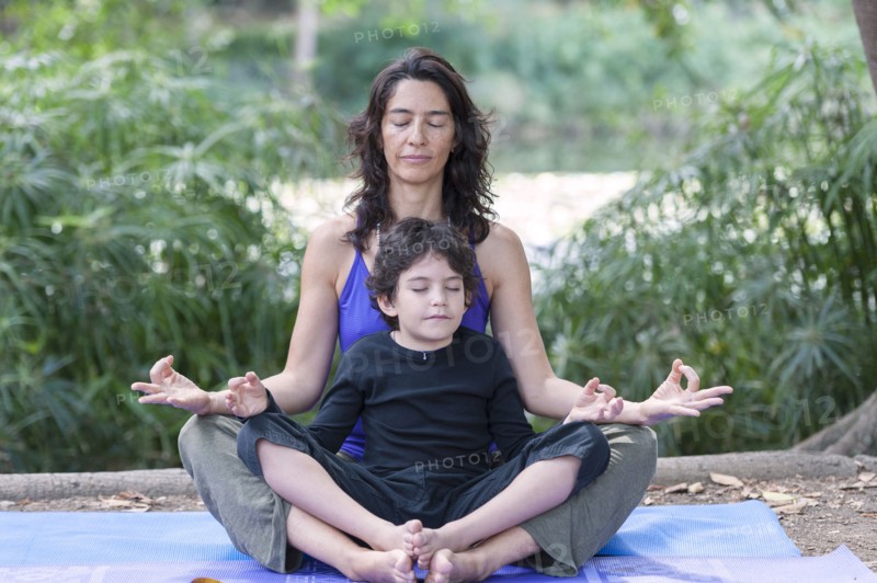 Hispanic mother and son practicing yoga