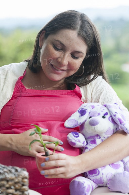 Pregnant Hispanic woman seedling in pot