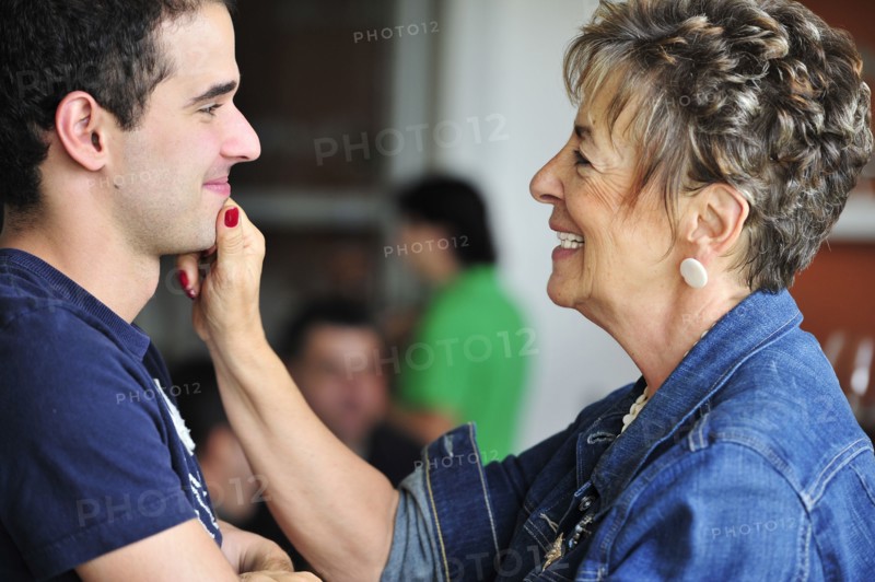 Hispanic grandmother pinching grandsons face