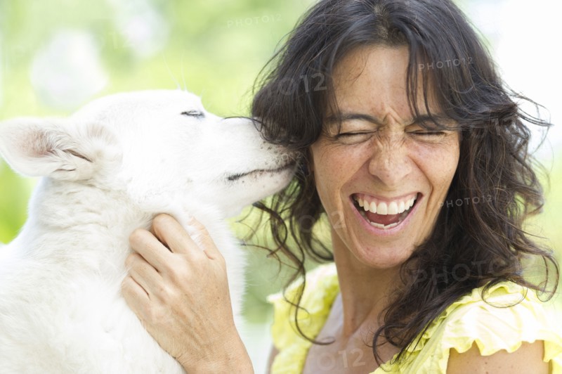Hispanic woman playing with dog