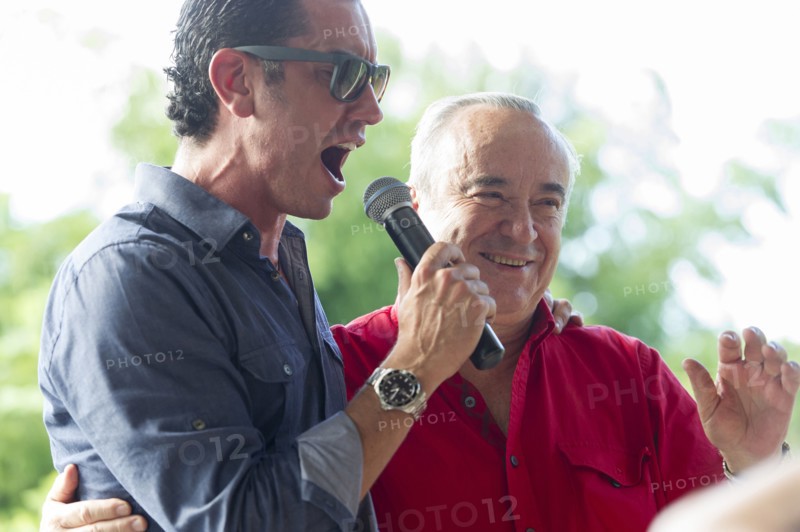 Grandfather and grandson talking into microphone at family reunion
