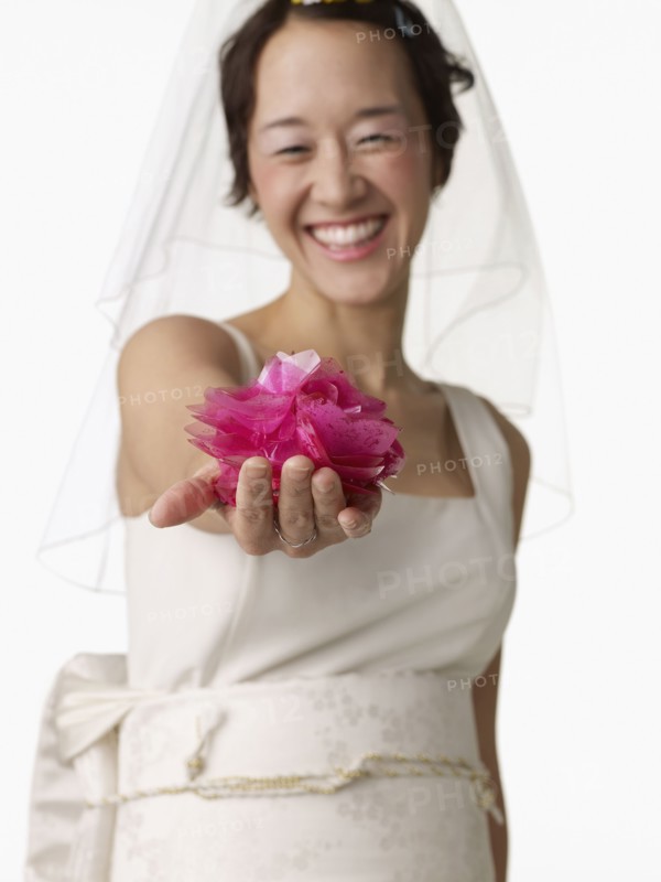 Asian woman in wedding dress holding flower