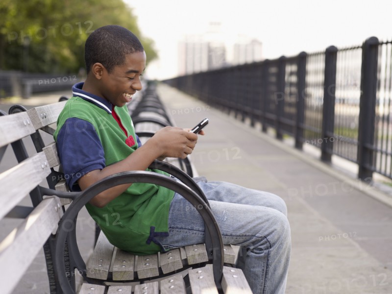African teenager text messaging on cell phone