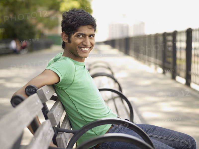 Indian man relaxing on park bench
