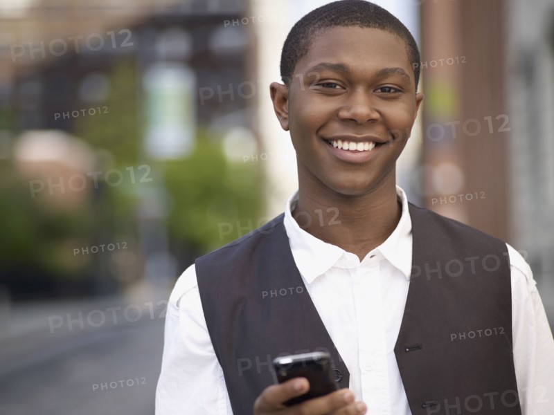 African man text messaging on cell phone