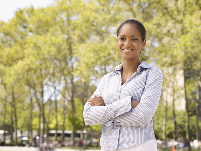 Mixed race woman with arms crossed in park