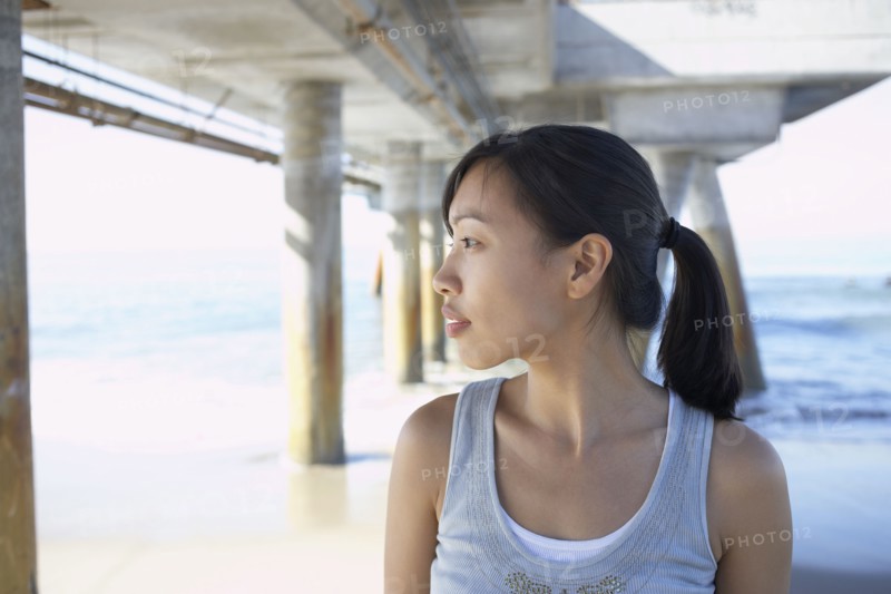 Asian woman under pier at beach