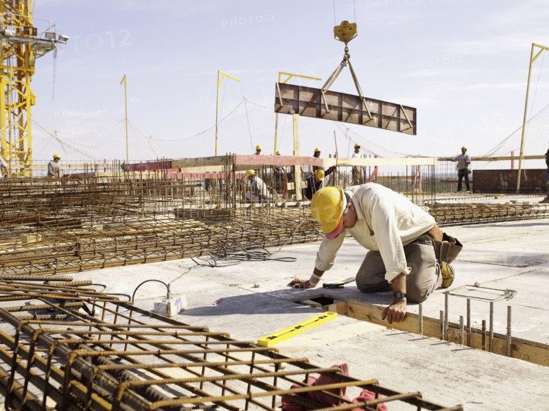 Hispanic worker kneeling at construction site