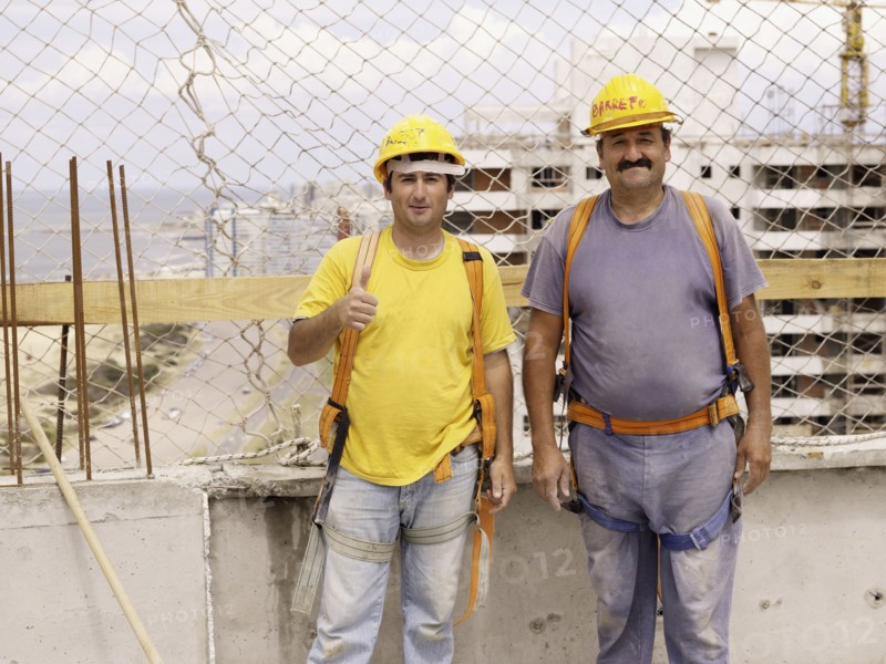 Hispanic workers smiling on construction site