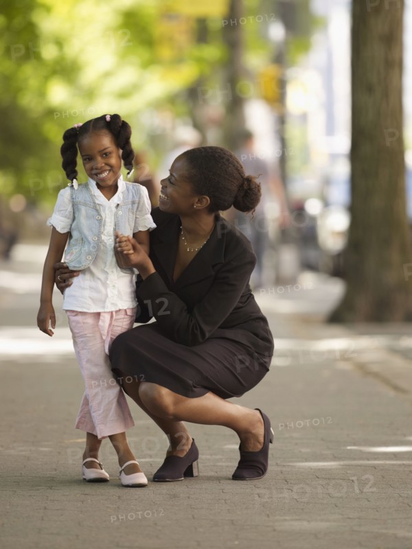 African businesswoman hugging girl
