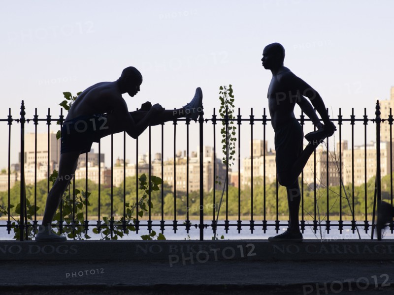 African men stretching on railing