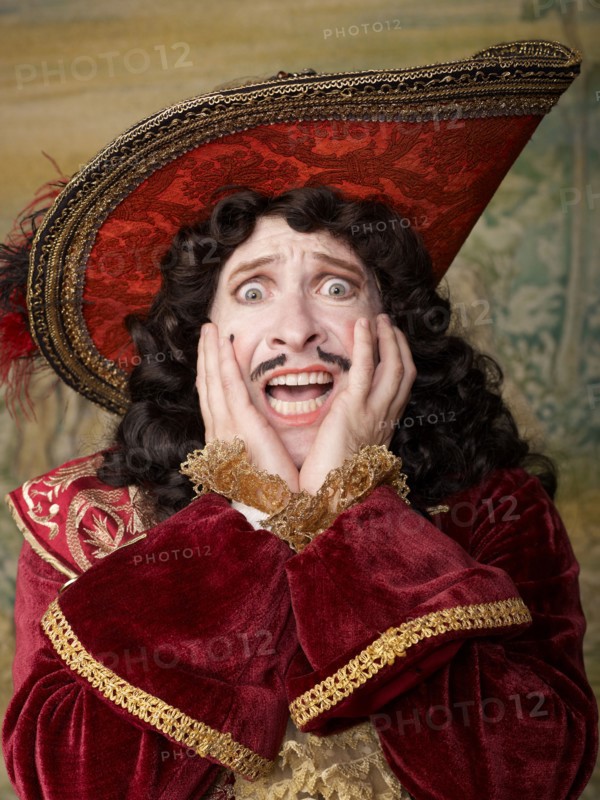 Shocked actor dressed in old-fashioned costume on stage