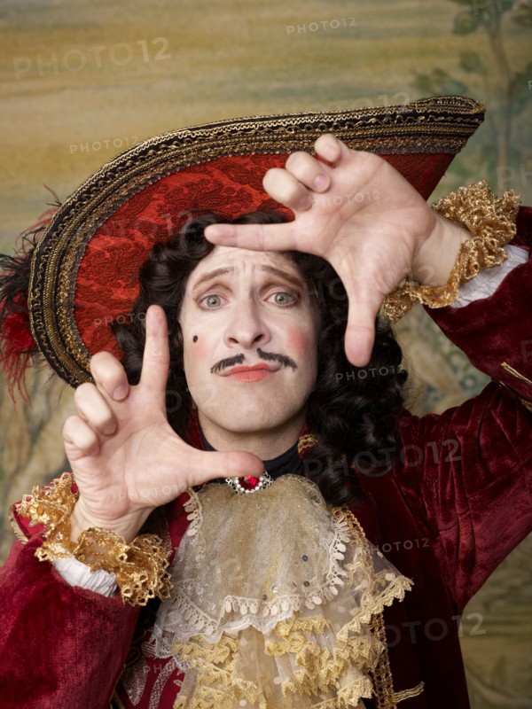 Actor dressed in old-fashioned costume making frame gesture