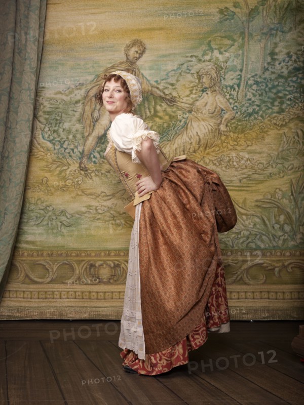 Actress dressed in old-fashioned costume on stage