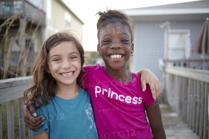 Grinning girls hugging outdoors