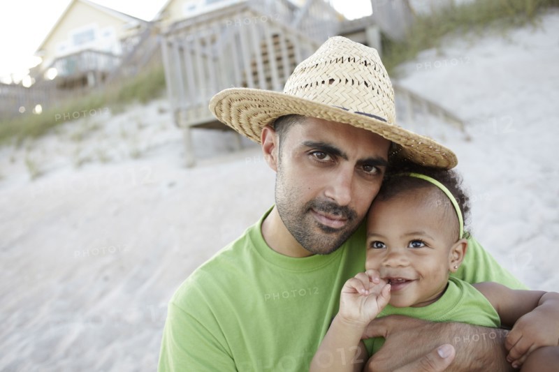 Father holding daughter on beach