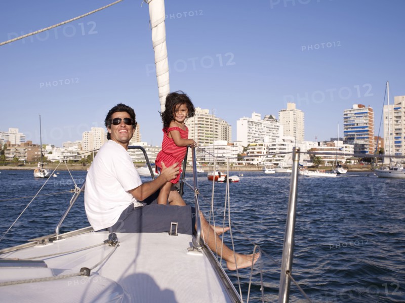 Hispanic father and daughter on sailboat