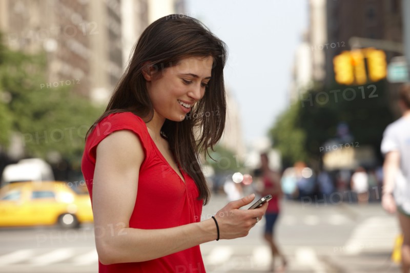 Caucasian woman using cell phone in city street