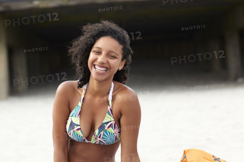 Laughing mixed race woman on beach
