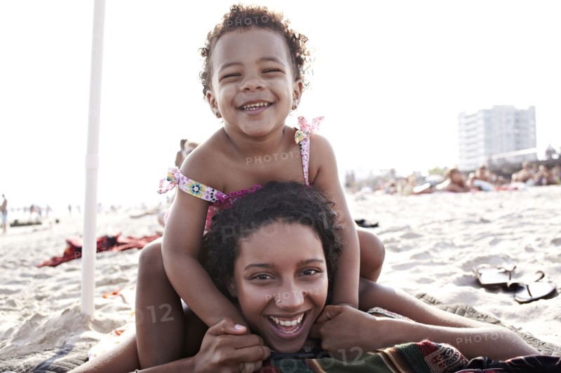 Mixed race mother and daughter enjoying the beach