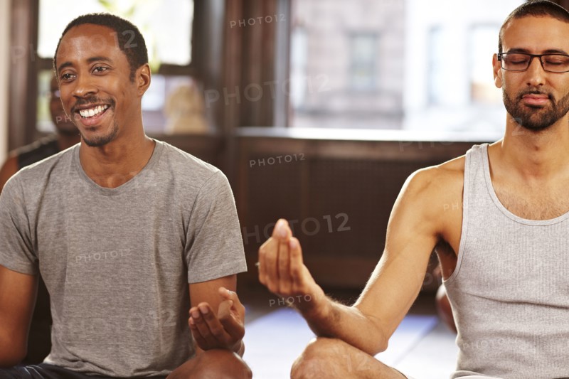 Men meditating in yoga class