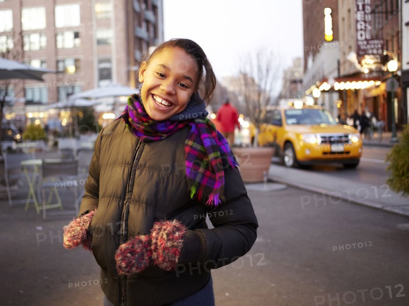 Mixed race girl smiling on city street