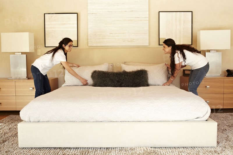 Hispanic women making bed