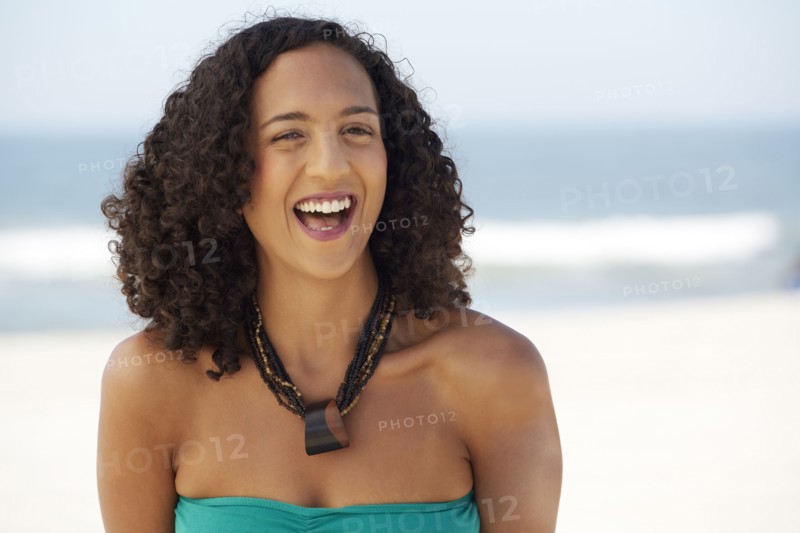 Mixed race woman smiling on beach
