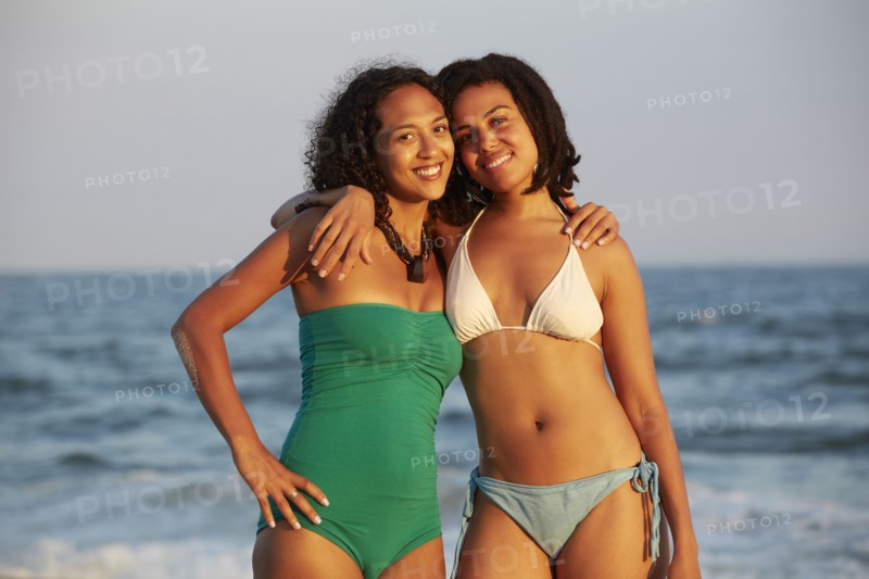Women smiling together on beach