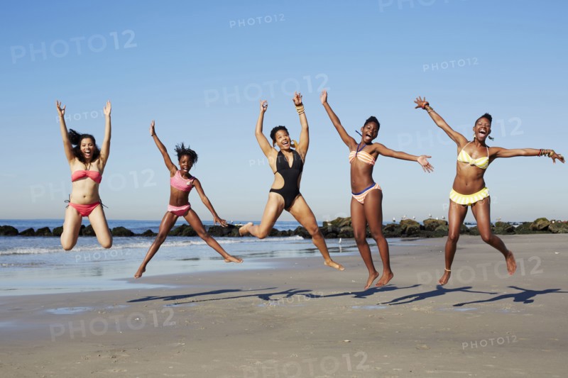 Women jumping for joy on beach