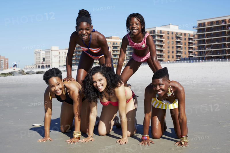Women forming pyramid on beach