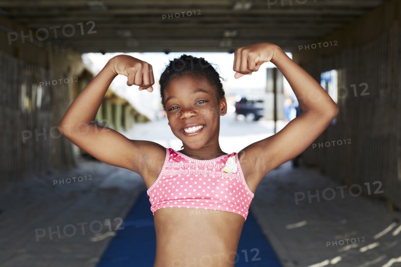 Black girl flexing muscles outdoors