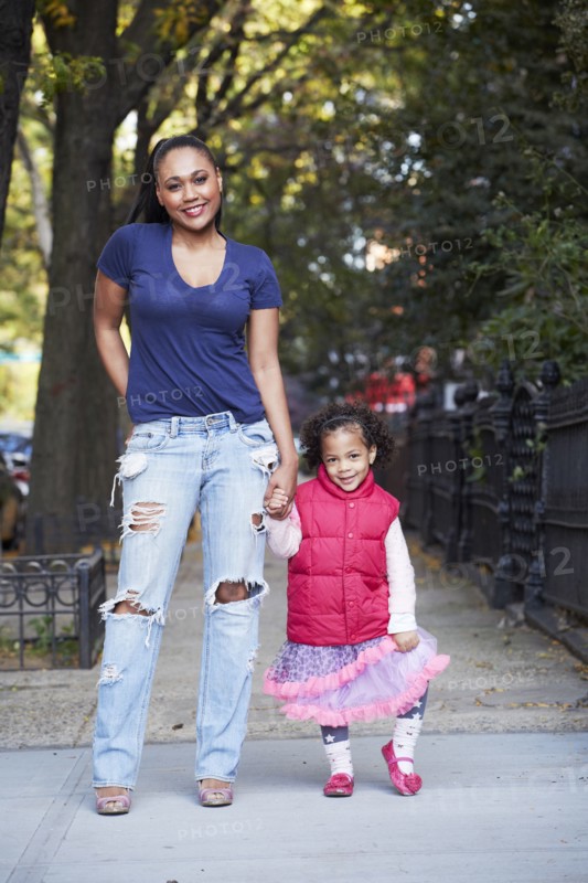 Mother and daughter standing on city street