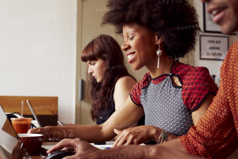 People using technology in coffee shop