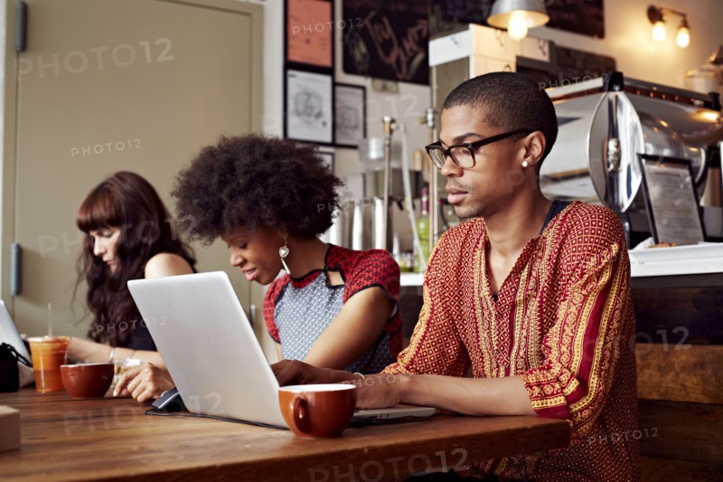 People using technology in coffee shop