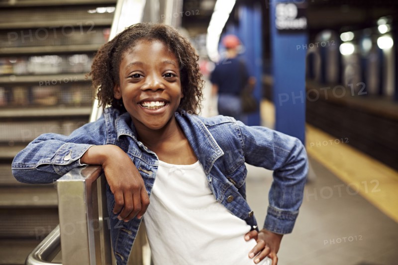 Smiling girl leaning on subway staircase