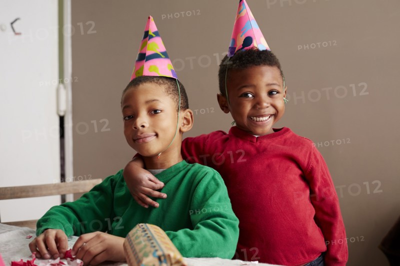 Black boys smiling in party hats