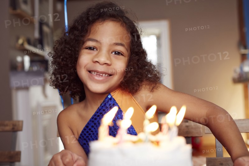 Mixed race girl with cake and candles