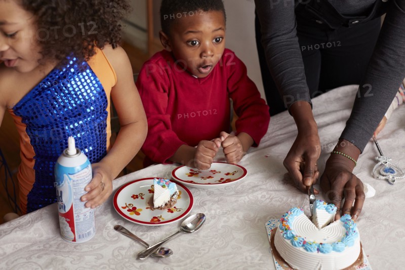 Excited children anticipating cake at party