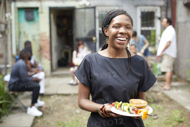 African American woman eating at backyard barbecue