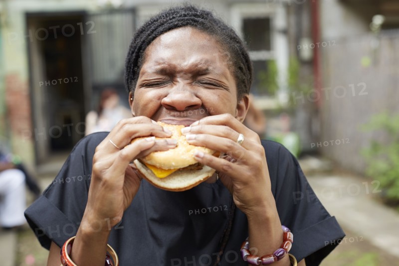 African American woman eating at backyard barbecue